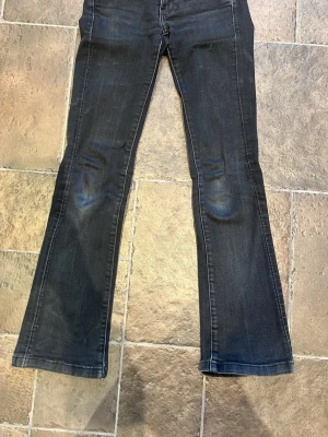 Svarta bootcut jeans från G-Star RAW - Säljer ett par svarta jeans från G-Star RAW med bootcut passform. Jeansen har snygga sömmar och en mörk tvätt. Materialet är jeans och de har en normal passform i midjan/är midwaist 