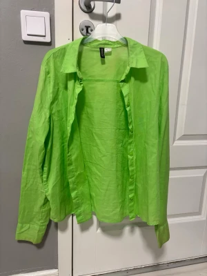 Grön skjorta från H&M  - Skjortan har klassisk krage, långa ärmar och knäppning framtill. Perfekt för dig som vill sticka ut med en poppig färg. 
