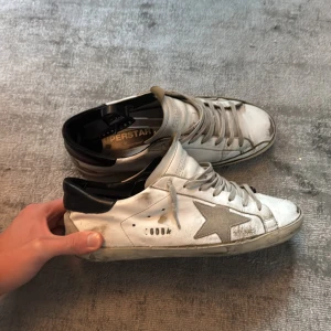 Golden Goose vita sneakers med stjärna - Storlek 43, nypris 4399 mitt pris 650kr. Använda men går lätt att fixa upp med lite lim. Undersidan på skon är fortfarande i helt okej skick. Kan köpas billigare på annan second hand sida v i n t e d 