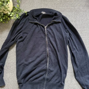 Mörkblå kofta från Dressmann i bomull - Snygg mörkblå kofta från Dressmann i mjuk Supima-bomull. Modellen har hel dragkedja framtill, ribbad krage och muddar vid ärmslut och nederkant. Perfekt för lager-på-lager och enkel att matcha med jeans eller chinos.