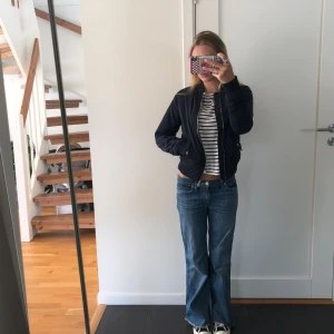 Mörkblå bomberjacka med dragkedja - Snygg mörkblå bomberjacka med klassisk passform och dragkedja framtill. Jackan har ribbade muddar vid ärmslut och midja samt fickor med lock. Perfekt för dig som gillar en stilren och enkel look.