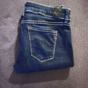 Replay LUZ skinny jeans mörkblå - Snygga Replay LUZ jeans i mörkblå tvätt med kontrastsömmar och klassisk femficksdesign. Modellen är skinny fit med låg midja och tillverkad i stretchig bomullsdenim för en bekväm passform. Perfekta för dig som gillar en tight och modern look.