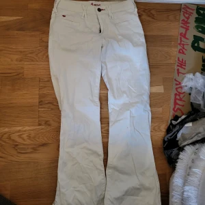 Vita bootcut byxor från Crocker S - Snygga vita byxor från Crocker i modellen Lucy, med bootcut-ben och låg midja. Byxorna har diskreta fickor fram och bak, bälteshällor och en liten röd hjärt-detalj. Hör av er vid frågor!💞