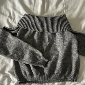 Grå of shoulder tröja - Säljer en grå of shoulder tröja. Tröjan är stickad och har långa ärmar samt ribbade muddar vid ärmslut och nederkant. Vet ej vart den är ifrån då jag klippt bort lappen samma med storlek men tror den är i xs!