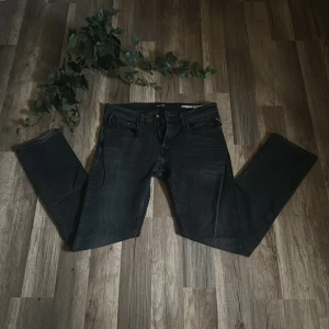Svarta Replay Dave jeans comfort fit - Säljer ett par svarta Replay Dave jeans i comfort fit. Jeansen har klassisk femficksdesign, raka ben och snygg tvättad finish. Perfekta om du gillar en lite lösare passform och stilren look. Materialet är slitstarkt denim i bomull.