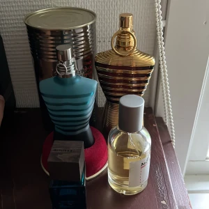 Jean Paul Gaultier Le Male & Ultra Male - Säljer två ikoniska herrparfymer från Jean Paul Gaultier: Le Male i blått, matt glas med turkosa ränder och Ultra Male i glänsande guldflaska, båda formade som en manlig torso. Perfekt för dig som gillar unika och snygga flaskor att ha på hyllan.