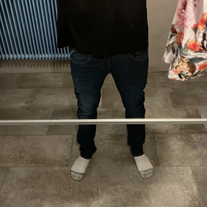 Replay Grover raka jeans mörkblå - Säljer ett par Replay Grover jeans i mörkblå tvätt med raka ben och klassisk femficksdesign. Jeansen har normal passform och är tillverkade i slitstarkt bomullstyg. Perfekta för dig som gillar en clean och tidlös look.