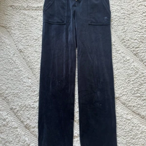  Juicy Couture S - Marinblå byxor från Juicy Couture med breda ben och stora fickor fram och bak. Klassisk broderad JC-logga på ena fickan och dragsko i midjan. Säljer även Teöjan till denna som finns på ett annat inlägg❤️ är tillgänglig i Skövde,Borås & Värnamo