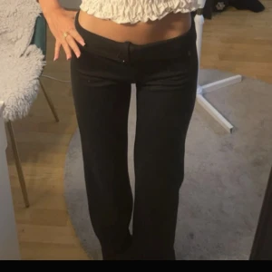 Svarta bootcut kostymbyxor  - Säljer ett par svarta bootcut kostymbyxor. man kan vika ner dom så dom blir låga som jag gjorde på första bilden. lite defekter längst ner då dom är lite långa på mig så jag har trampat där. Mjukt material