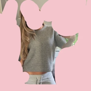 Grå stickad kortärmad tröja från Zara - Supermjuk grå stickad tröja från Zara med korta ärmar och rund hals. Tröjan har en enkel och clean look med ribbade kanter. OBS Jag har storlek S, dock är tröjan väldigt liten i storleken så den är i storlek XL. Men man kan se hur den sitter på mig som har S på bilden för referens. 
