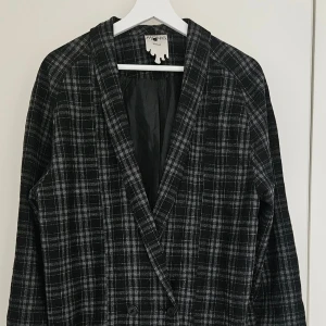 Monki rutig kavaj - Oversized Kavaj i svart/grå rutigt mönster från Monki. Modellen är dubbelknäppt med stora framfickor och rak passform.  Strl S,  Använd få gånger, mycket fint skick.