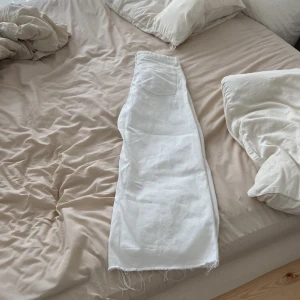 Vita vida jeans från Zara - Säljer ett par vita jeans från Zara med breda ben och råa, fransiga kanter längst ner. Modellen är middle waist skulle jag säga. De har klassiska fem fickor samt dragkedja och knapp framtill. Perfekta för dig som gillar en chill och trendig look. Syperskick!🩷