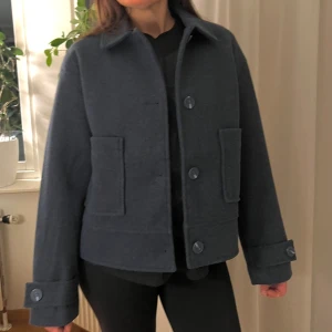 Blå kort kappa - Snygg blå kappa med klassisk krage och stora knappar framtill. Färgen är som på sista bilden i verkligheten!