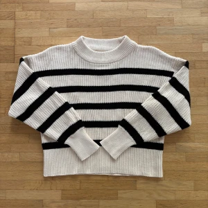 Randig stickad tröja från Part Two - Säljer en snygg stickad tröja från Part Two i storlek S. Tröjan är vit med svarta ränder, har en ribbad hög hals och långa ärmar. Perfekt för dig som gillar klassisk stil med en twist. Materialet är mjukt och känns riktigt skönt mot huden. Lite liten i storleken så skulle säga att den passar XS bättre än S.