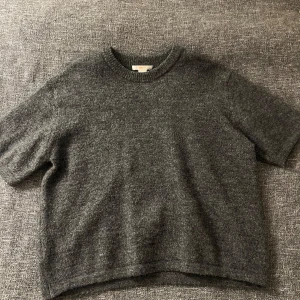 Mörkgrå stickad tröja från Gina Tricot -  mörkgrå stickad tröja från Gina Tricot med korta ärmar. Pris kan diskuteras