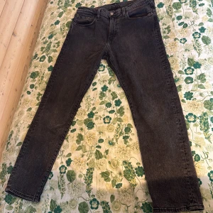 Levi's 502 svarta jeans W33 L30 - Säljer ett par svarta Levi's 502 jeans med klassisk femficksdesign och raka ben. Jeansen har en snygg mörk tvätt och är tillverkade i slitstark bomullsdenim. Perfekta för dig som gillar en clean och tidlös look.