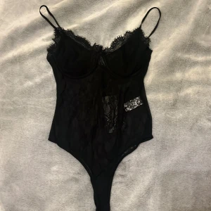 Svart spetsbody från Zara - Säljer en supersnygg svart body från Zara i storlek M men skulle säga att den passar mer mot S.   Framsidan är spets och baksidan är mer genomskinligt svart tyg ( se sista bilden) Helt oanvänd med prislapp kvar, säljer då den aldrig kommer till användning. 