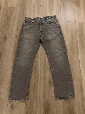 Grå jeans från Jack & Jones, 32/32 - Säljer ett par riktigt snygga jeans från Jack & Jones i storlek 32/32. Jeansen är i grå färg med avslappnad passform