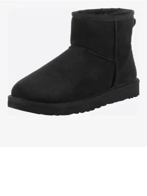 Uggs - Säljer ett par svarta boots med rund tå och platt sula. Skorna är tillverkade i mjuk mocka och har en enkel, klassisk design utan snörning eller dragkedja. Perfekta för kalla dagar och passar till många olika stilar.