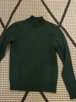 Mörkgrön polotröja från Vila XS - Snygg mörkgrön polotröja från Vila i storlek XS. Tröjan har ribbad hög krage och muddar vid ärmslut och nederkant. Den är superskön att ha på sig och är len!