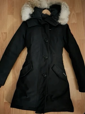 Canada Goose Jacka  - Säljer en svart dunjacka från Canada Goose med fluffig päls luvan. Jackan är i väldigt bra skick och har inga skador! 