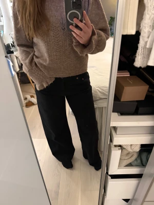 Svarta low waist jeans från Motel rocks  - Säljer ett par svarta jeans från Motel rocks med breda ben och låg midja. De är aldrig använda och har prislappen kvar. Orginalpris är 833 kr, storlek W30/ L32
