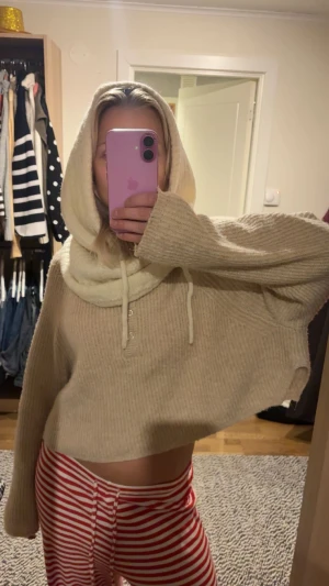 Stickad krämvit huva/balaklava  - Säljer en stickad krämvit huva med snörning framtill. Huvan är ribbad och mjuk o perfekt för vintern o våran!!🥰Helt ny med prislapp 