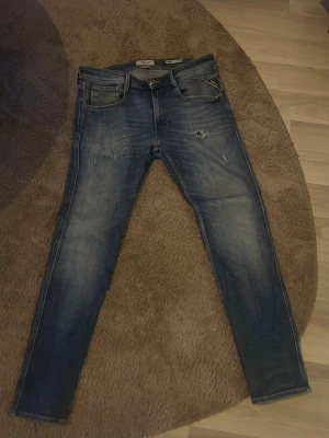 Replay Anbass skinny jeans blå - Säljer ett par Replay Anbass jeans i mörkblå tvätt med slitningar och skinny/slim passform. Klassisk femficksmodell med dragkedja och knapp, samt Replay-logga på bakfickan. Jeansen är gjorda i stretchigt bomullsmaterial för skön komfort. Pris går att diskuteras     Storlek är w31/L30