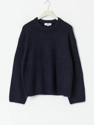 Mörkblå stickad tröja - Mysig mörkblå stickad tröja från gina med rund halsringning och ribbade muddar. Perfekt för kyliga dagar och enkel att styla med jeans eller kjol. Tröjan har en relaxed passform och långa ärmar.