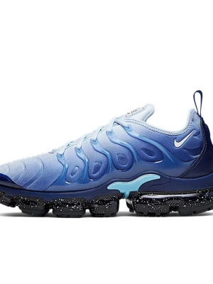 Nike Air Vapormax Plus blå sneakers - Nike Air Vapormax Plus sneakers i en snygg blå färggradient med svarta och vita prickiga detaljer på sulan. Ovandelen är i syntetmaterial med vågiga mönster och snörning. Sulan är genomskinlig och ger en futuristisk vibe. Perfekt för dig som vill sticka ut med dina skor.