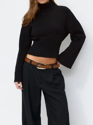 Svart croppad polotröja med vida ärmar - Säljer en svart croppad polotröja med bred ribbad midja och vida ärmar. Tröjan är stickad och har hög krage som ger en snygg och trendig look. Perfekt att styla med höga byxor eller kjol för en cool vibe. Fick hen den idag men efter flera prövningar tycker jag den inte sitter bra på mig. Råkade klippa bort prislappen men nypris ligger på runt 439. 