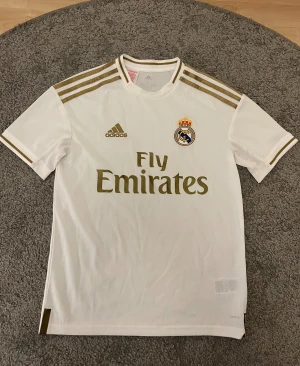 Real Madrid tröja  - Säljer en officiell Real Madrid matchtröja från adidas i barnstorleken L. Tröjan sitter S/XS i normal storlek. Aldrig använd.