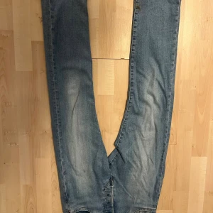 Levi's 501 Premium jeans blå W27 L30 - Klassiska Levi's 501 Premium jeans i ljusblå tvätt med raka ben och fem fickor. Jeansen har knappgylf och snygga slitningar på låren. Riktigt snygga jeans i bra skick och pris kan diskuteras!