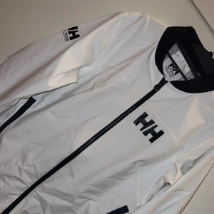 Vit jacka från Helly Hansen - Säljer en snygg vit jacka från Helly Hansen i mycket bra skick. Köpt för 1300