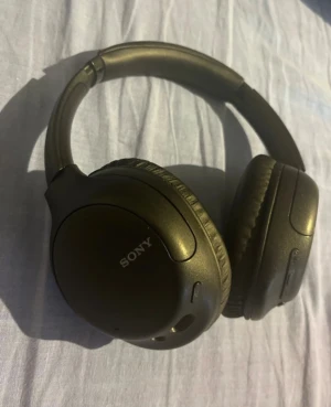 Sony WH-CH710N - Sony WH-CH710N trådlösa over-ear hörlurar med aktiv brusreducering. Bekväma öronkuddar, USB-C laddning och 3,5mm uttag. Fysiska knappar för volym och brusreducering. Hörlurarna är i väldigt gott skick men är sönder (bild 5) men den är inget som stör :) 
