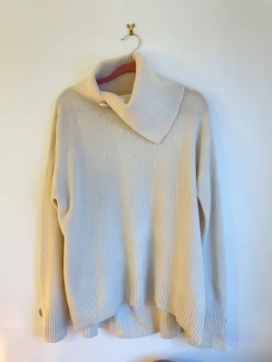 Benvit polotröja från Massimo Dutti - Säljer en benvit polotröja från Massimo Dutti i mjuk ull och kashmirmix. Tröjan har en bred, ribbad polokrage, långa ärmar och ribbade muddar vid ärmslut och nederkant. Passformen är loose och den har en clean, stilren look.