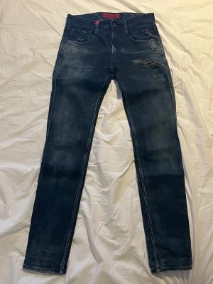 Svarta Replay Jeans Anbass - Jag säljer svarta Replay Anbass jeans. Det är en äldre modell men såklart äkta. Dem har inga tecken på användning och absolut inga defekter. När man köper jeansen nya har dem redan slitningarna. Skickar extra fort eftersom det börjar närma sig jul. Storleken är waist 28 och length 32. Skriv vid frågor eller om ni vill ha fler bilder.
