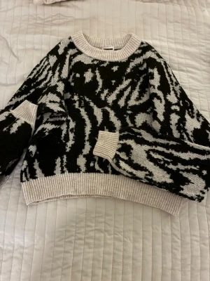 Zebramönstrad stickad tröja Noisy May - Säljer en jätte snygg stickad tröja från Noisy May i Xss passar även som en Xs/S .svart och vitt zebramönster. Tröjan har ribbade muddar vid hals, ärmslut och nederkant. långärmad, perfekt för att hålla sig varm och snygg under vinter.