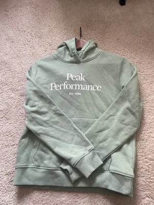 Grön hoodie från Peak Performance - Snygg ljusgrön hoodie från Peak Performance säljer denna jätte fin grön färg hoodie då den inte har kommmit till användning 