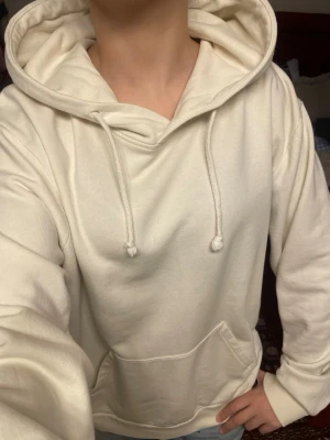 Krämvit hoodie med ficka - Säljer en krämvit hoodie med stor huva och dragsnören. Hoodien har en klassisk känguruficka framtill och ribbade muddar vid ärmslut och nederkant. Perfekt oversized passform för en chill och avslappnad stil. Materialet känns mjukt och bekvämt. PRIS KAN DISKUTERAS❤️❤️❤️❤️KÖP NUU