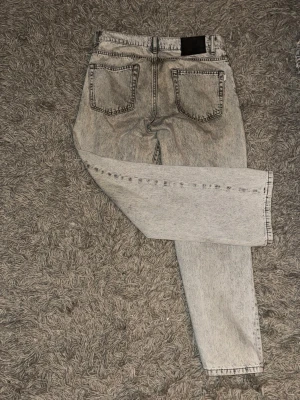 Grå woodbird jeans  - Säljer ett par gråa woodbird jeans 29/30, med rak passform och coolt tvättad finish. Perfekta för dig som gillar en avslappnad och trendig stil. Ny pris 1100kr 