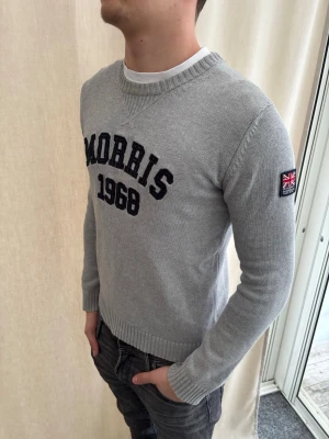 Stickad tröja från Morris  - Snygg ljusgrå tröja från Morris i strl M. Riktig skön passform. Personen på bilden är 184 cm lång. Skicka prisförslag. 