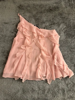 One-shoulder topp med volanger - Super sött topp med volanger och one-shoulder. Hundhår kan finnas på plagget. Oanvänd utan prislapp. Skriv för bild på🩷