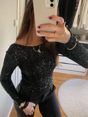 Svart glittrig långärmad topp - Lägger ut igen för frifrakt! Snygg svart topp med glittriga paljetter och lång ärm. Storlek M men som en xs/s