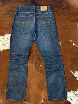  Nudie Jeans - Säljer ett par klassiska mörkblå jeans från Nudie Jeans med raka ben och femficksmodell. Modellen på jeansen heter di