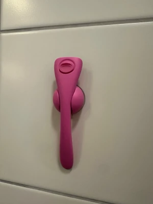 Rakhyvel med väggfäste rosa ESTRID - Säljer en rosa rakhyvel med matchande väggfäste som fästs med sugpropp på kakel eller andra släta ytor. Handtaget är ergonomiskt format och hela setet är gjort i plast. Perfekt för att hålla rakhyveln lättillgänglig i badrummet.