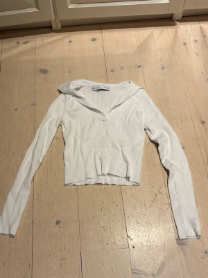 Vit ribbad långärmad topp från Bershka - Vit ribbad långärmad topp från Bershka med v-ringad hals och croppad passform. 