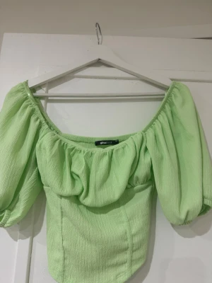 Grön topp Gina Tricot - Trendig ljusgrön offshoulder topp från Gina Tricot med puffiga ärmar och strukturerat tyg. Toppen har en inbyggd korset som formar otroligt, ändas använd en gång💗