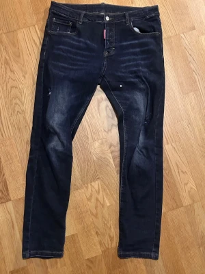 Mörkblå jeans från Dsquared2 - Snygga mörkblå jeans från Dsquared2 med klassisk femficksdesign och diskreta slitningar. Jeansen är slim fit/ skinny fit, och storlek 32/32. Inga defekter.  Priset är inte hugget i sten! Kom DM för fler frågor. 