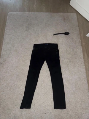 Svarta skinny jeans från G-Star RAW - Svarta skinny jeans från G-Star RAW med tryckt logga på fickan och klassisk femficksdesign. Jeansen har låg midja och smal passform, perfekta till en streetwear-look. Materialet är stretchigt för extra komfort.